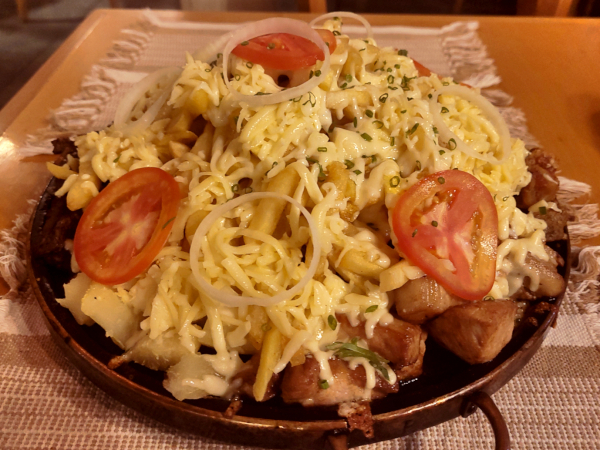 Foto de ambiente do restaurante, com mesas com cadeiras enfileiradas e boa iluminação.